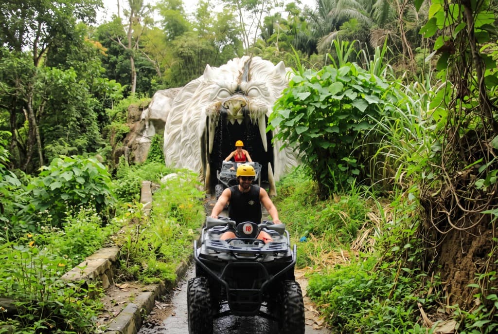 Riders on the Sedang ATV track emerging from the giant lion-head tunnel through the jungle