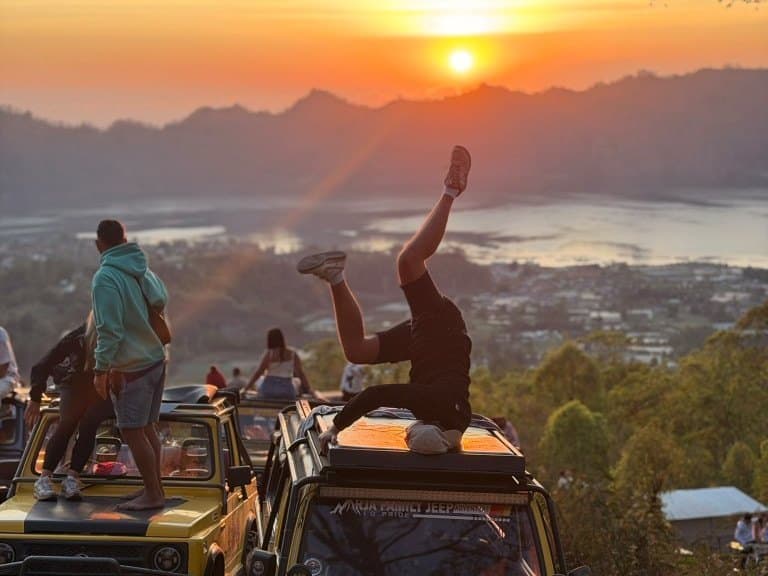 Guests on the roofs of yellow 4×4 jeeps at the Mount Batur sunrise viewpoint above Lake Batur