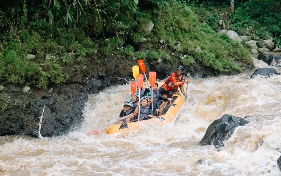 A raft dropping through Ayung white water, the afternoon half of the ATV and rafting day